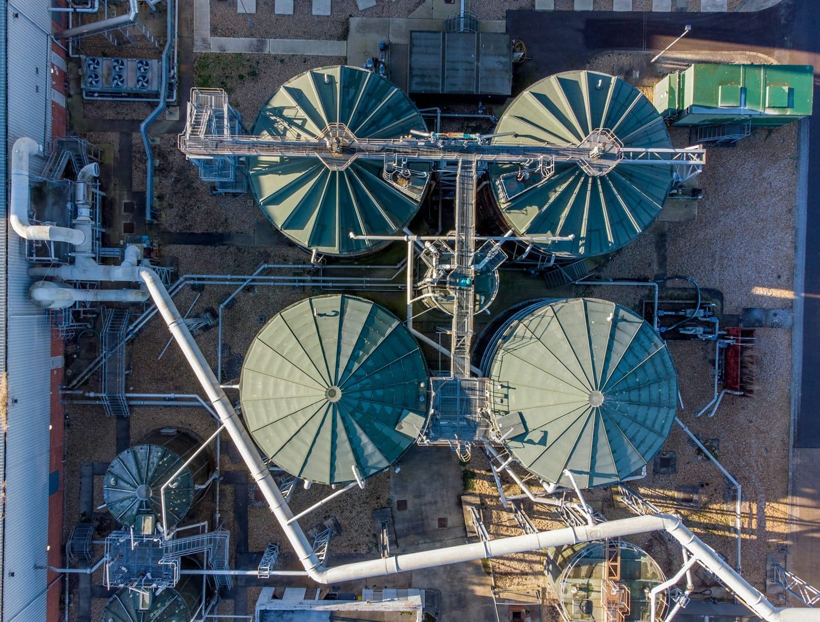 Aerial view of an industrial tank farm — circular storage tanks linked by pipework